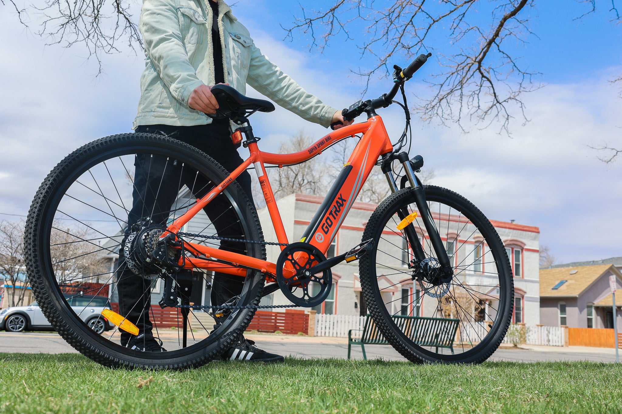 Man holding GOTRAX Red Alpha XL Electric Bike for Adults in a park