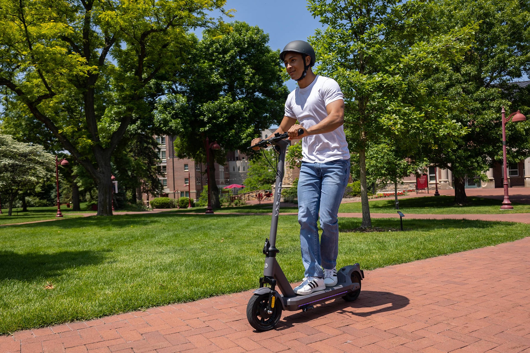 Man riding on a GOTRAX G5 Commuter Electric Scooter with Front Wheel Suspension
