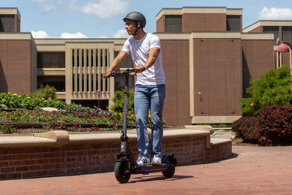 Man riding a GOTRAX G6 Commuter Electric Scooter with Front Wheel Suspension