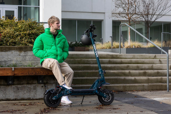 Man sitting next to a GORAX GX3 Performance Electric Scooter